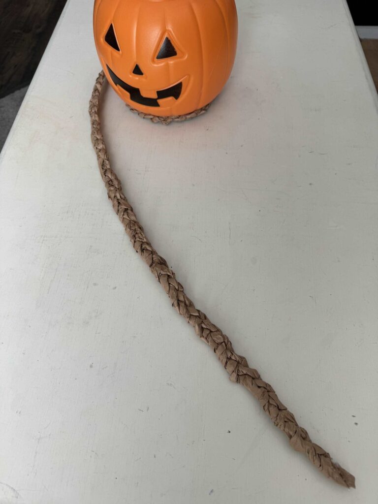 A braid of packing paper wrapped around a pumpkin pail. 