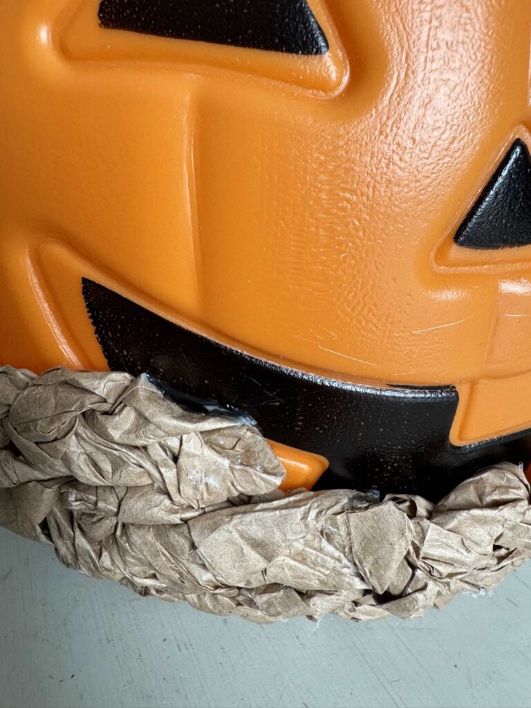 A braid of packing paper glued to a pumpkin pail. 