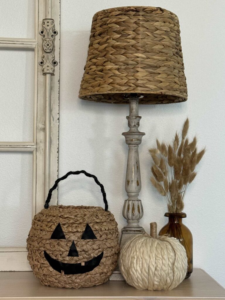 Halloween basket next to a yarn pumpkin and bunny tails. 