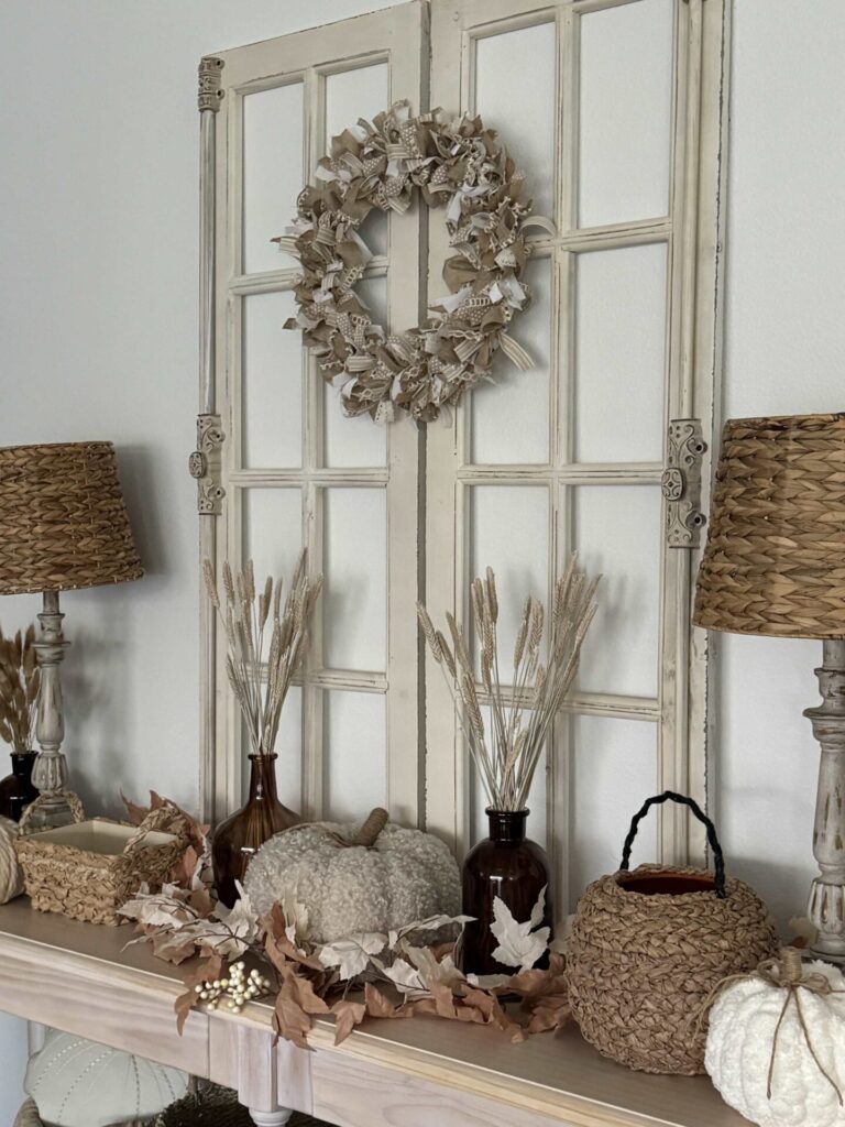 Console table decorated for Fall with baskets and pumpkins. 