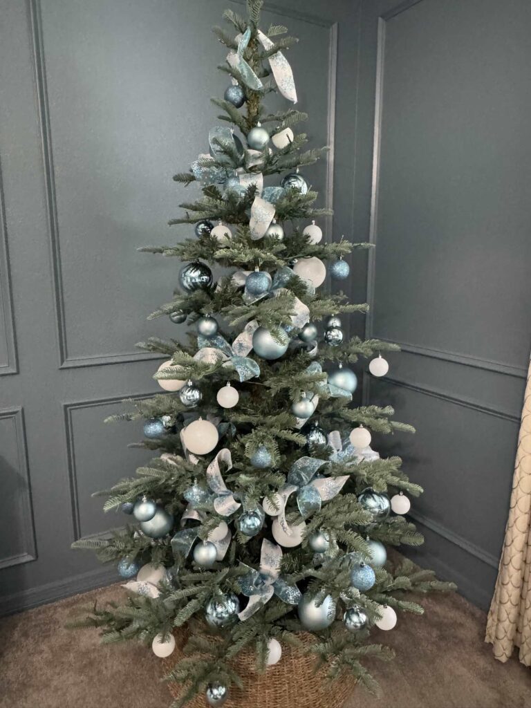 7' King Noble Fir Artificial Christmas Tree decorated with blue and white ornaments. 