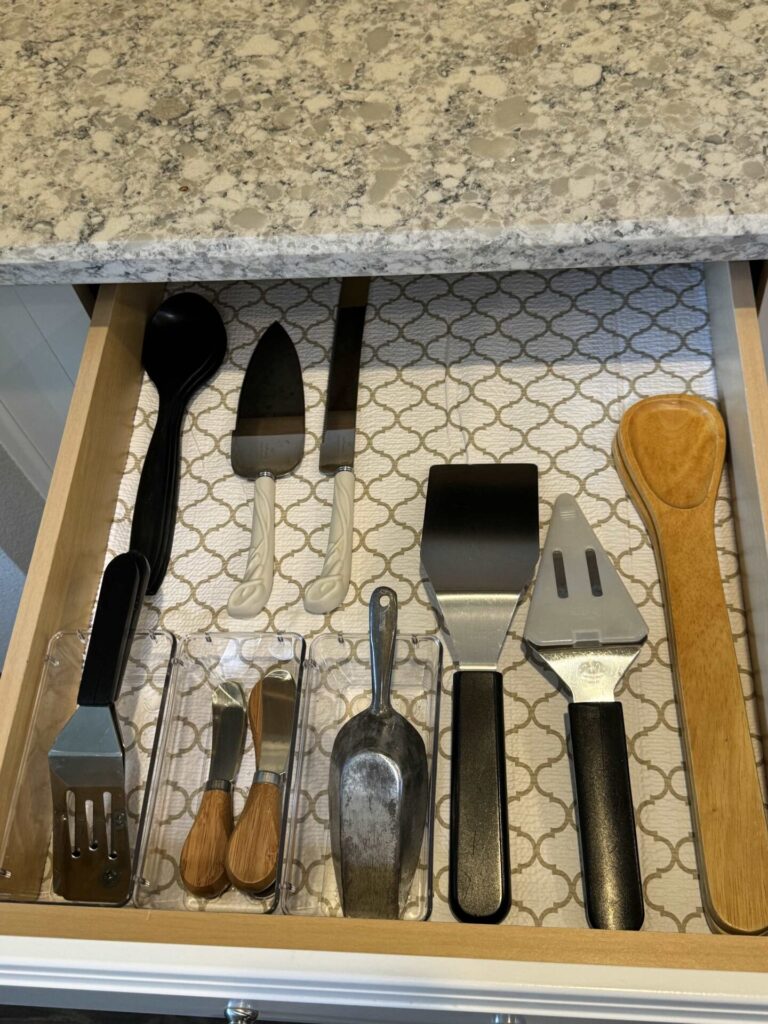 An organized drawer of serving utensils. 