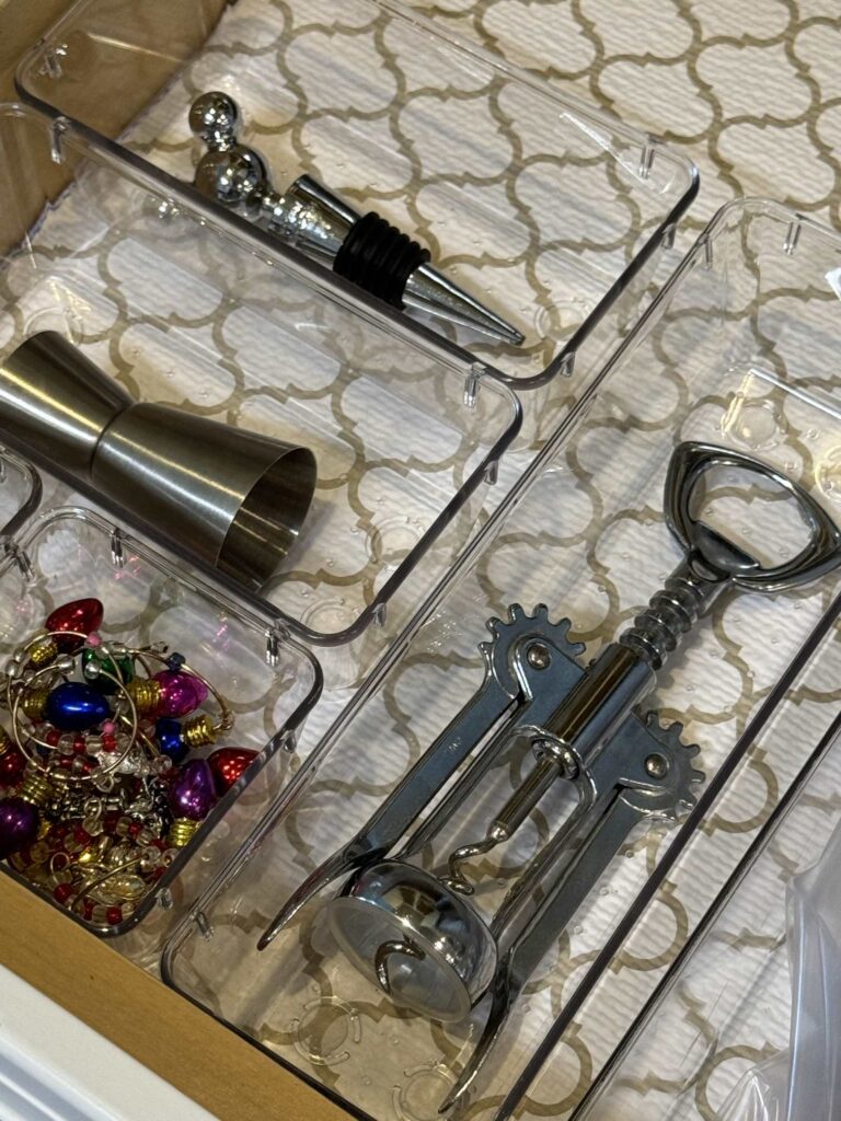 Bar accessories organized in clear drawer dividers.