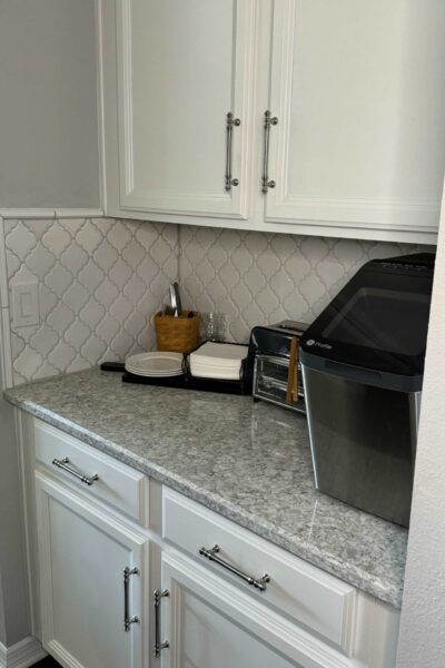 Butler's pantry counter organized as a breakfast station with toaster, plates, napkins, and eating utensils in a basket.