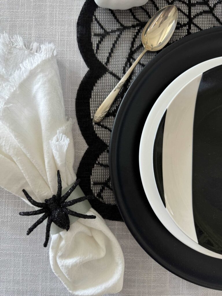 A napkin holder with a black spider. 