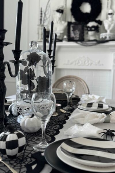 Dining table decorated for Halloween with black and white items.