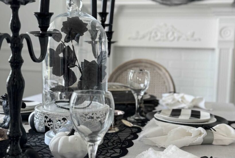 Dining table decorated for Halloween with black and white items.