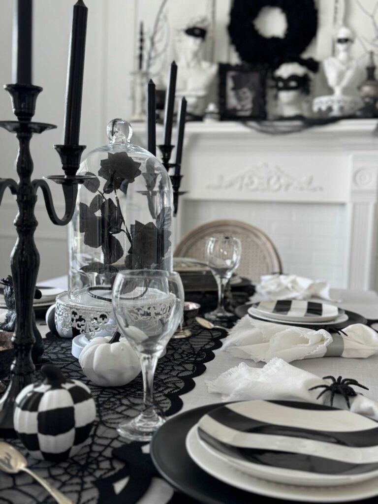 A dining room table decorated in a black and white spider theme. 