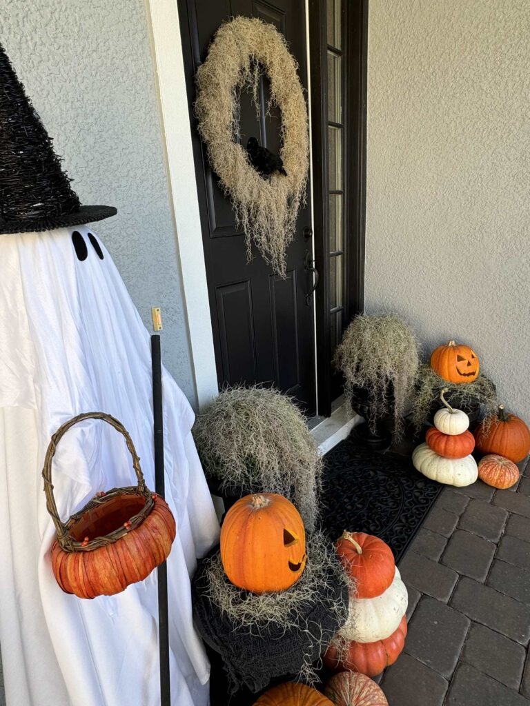 Halloween porch decor ideas using a ghost, orange and white pumpkins, and Spanish moss. 