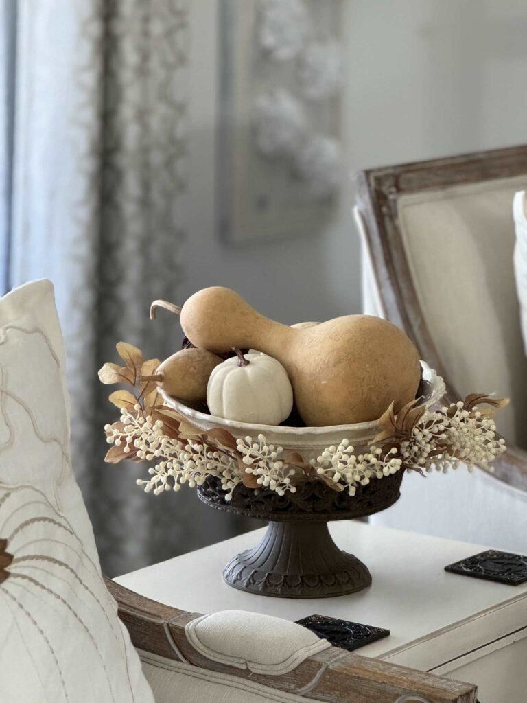 A fall arrangement with gourds and pumpkins in a bowl.