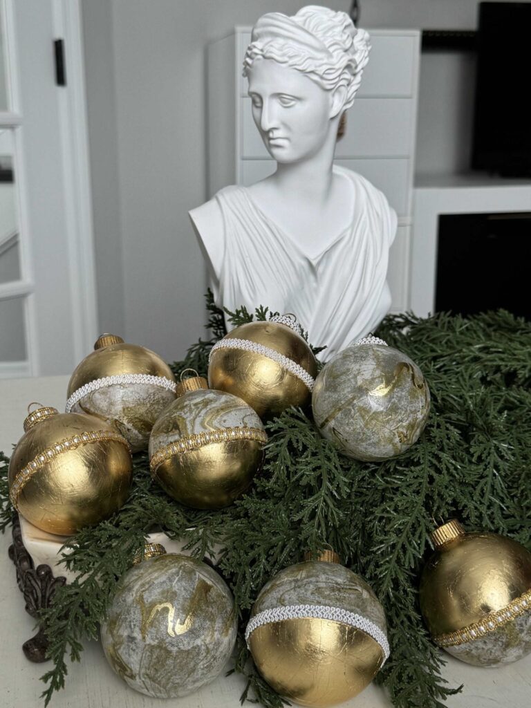 DIY gold leaf ornaments in front of a bust statue.