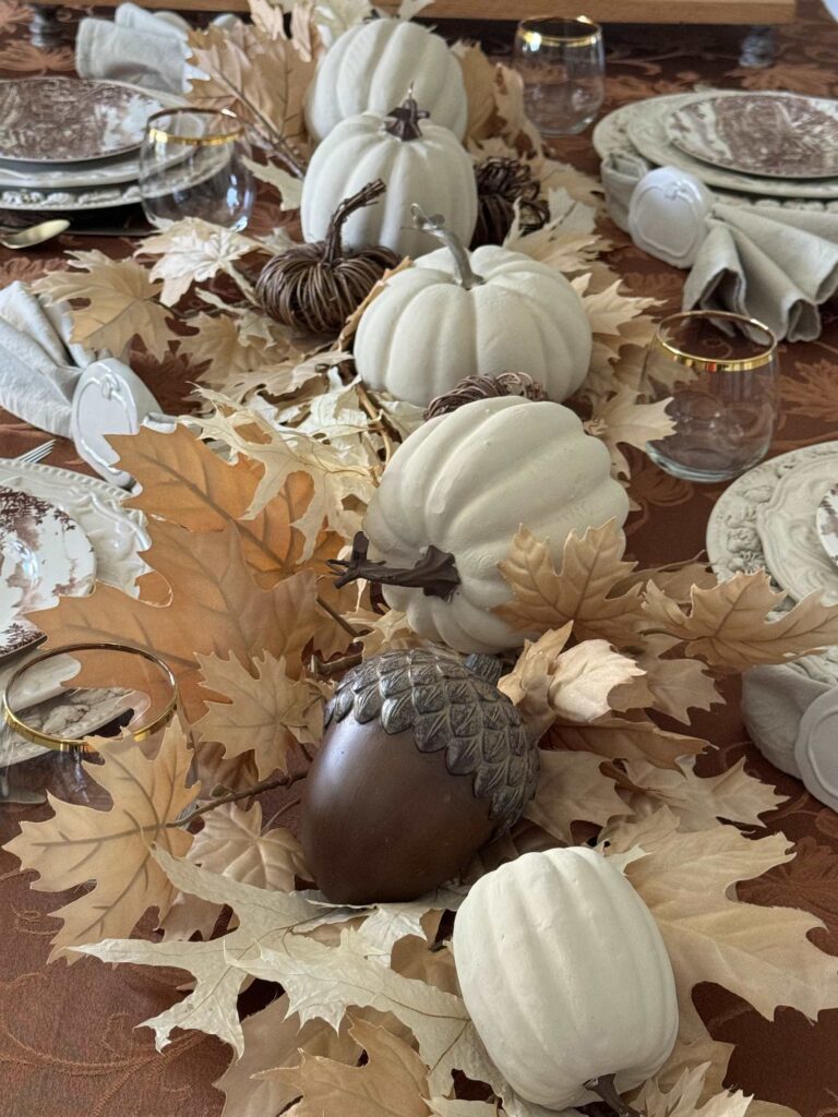 Pumpkin, leaf, and acorn centerpiece on a Thanksgiving tablescape. 