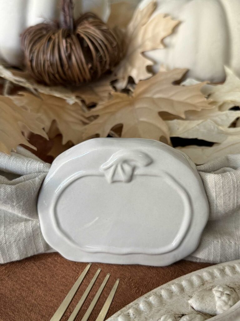 A cream pumpkin napkin holder. 