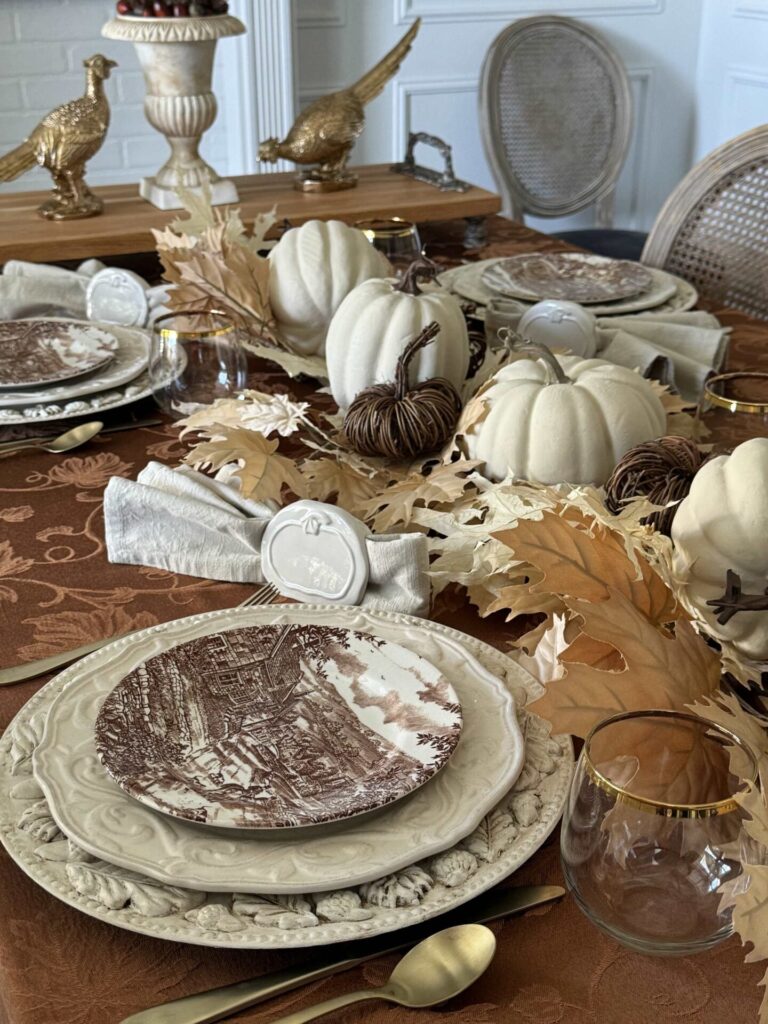 A Thanksgiving tablescape featuring gold pheasants and white pumpkins. 