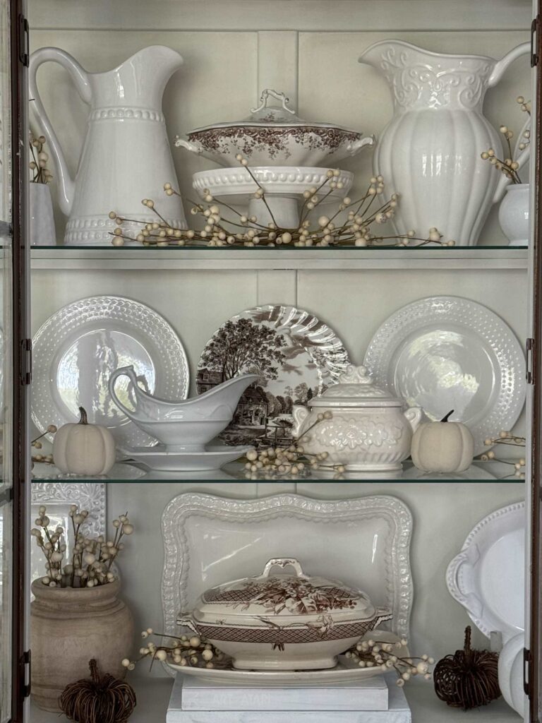 Ironstone and brown transferware styled in a china cabinet. 