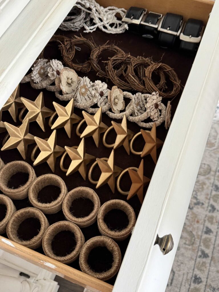 Napkin holders organized in a drawer of a china cabinet. 