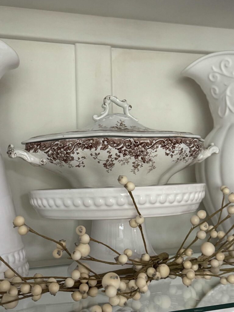 Brown transferware tureen on a white cake plate. 