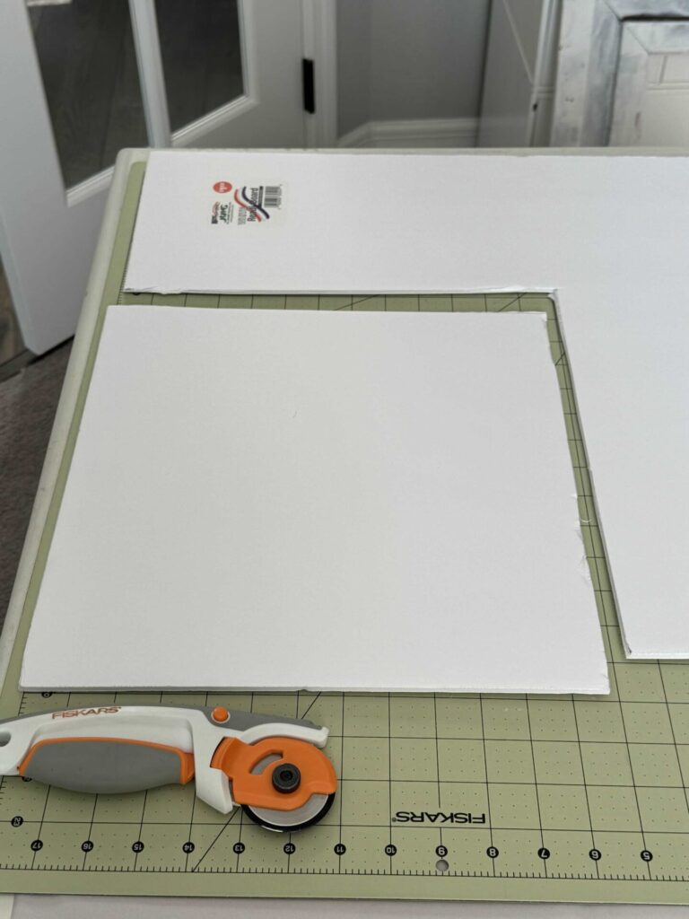 Step three to make DIY Christmas wall decor is to cut a foam board to fit inside a frame. 