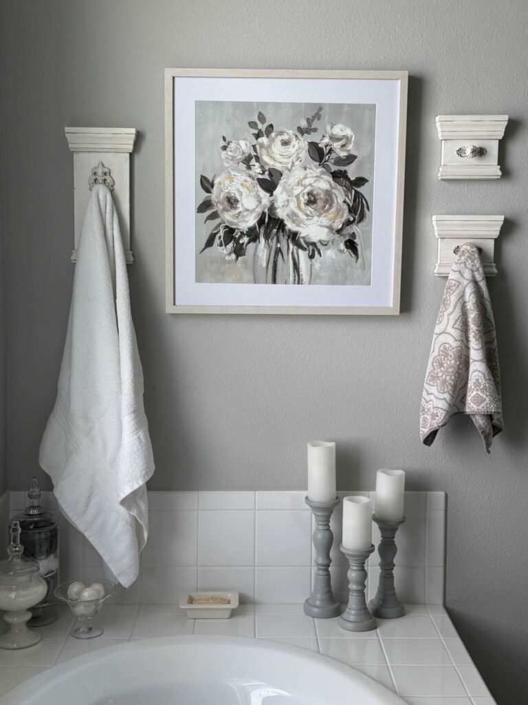 Three DIY wall hooks surrounding a floral picture.  