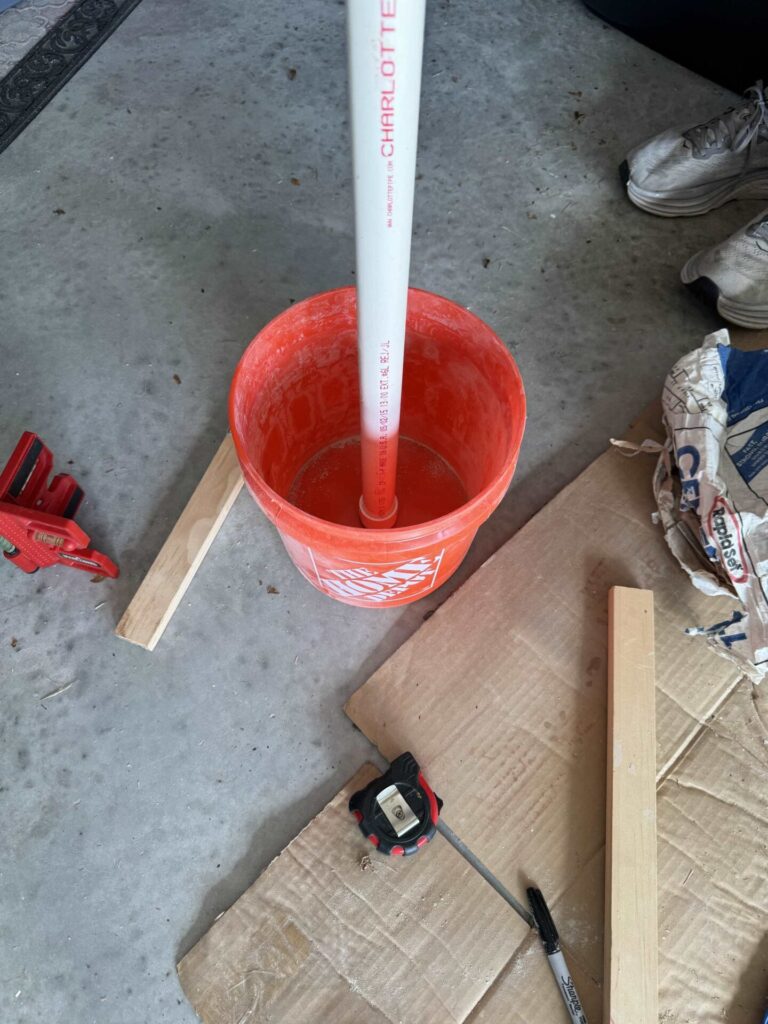 A white pipe with cap in a Home Depot small bucket. 