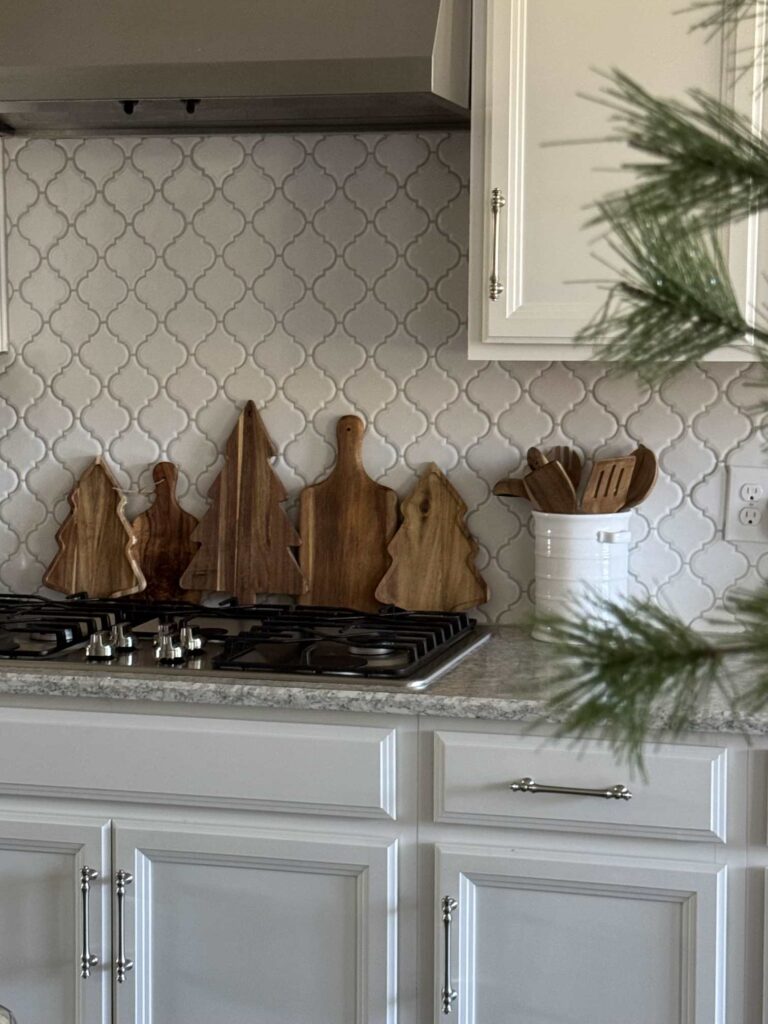 Wood cutting boards and trees behind a stove. 