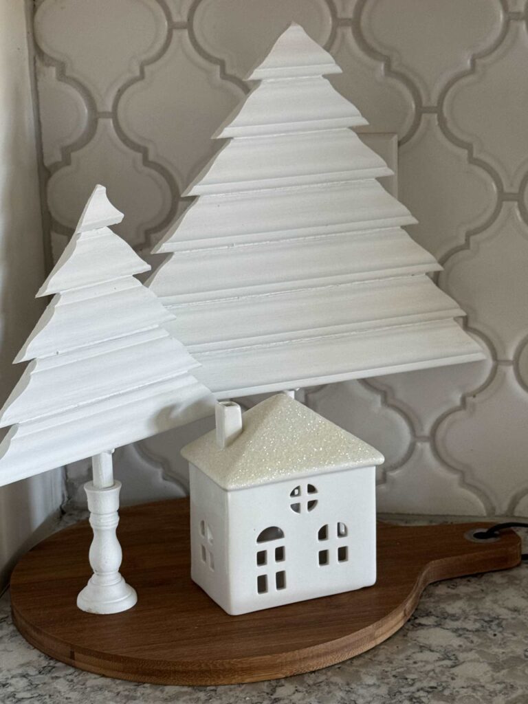 Wood trees and ceramic house on a cutting board. 