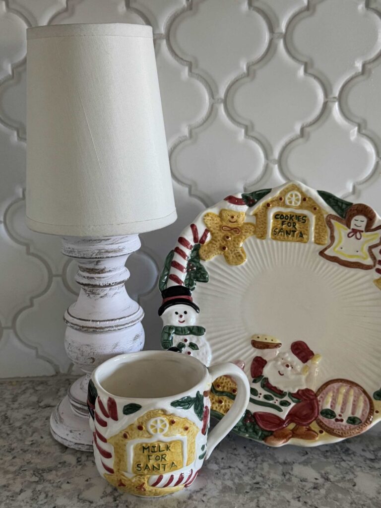 Plate and mug for Santa Christmas cookies next to small lamp. 