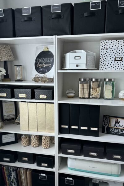 White organized shelves with black and gold containers.