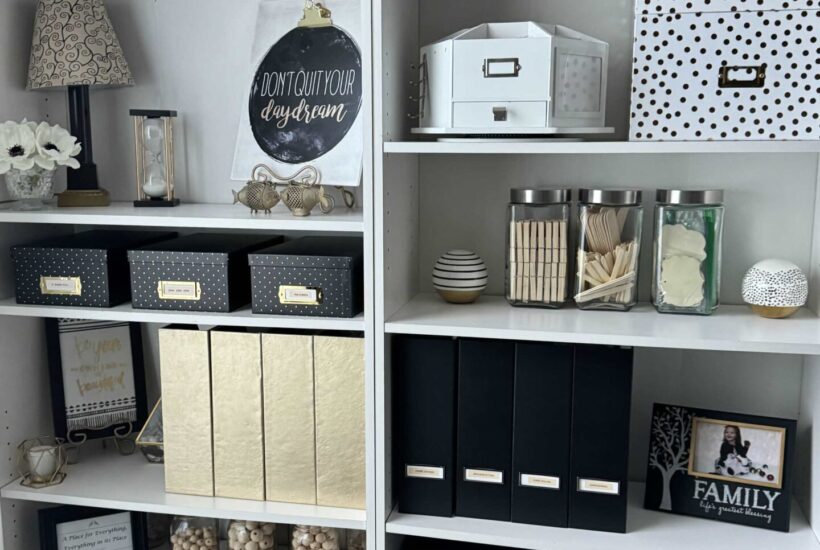 White organized shelves with black and gold containers.