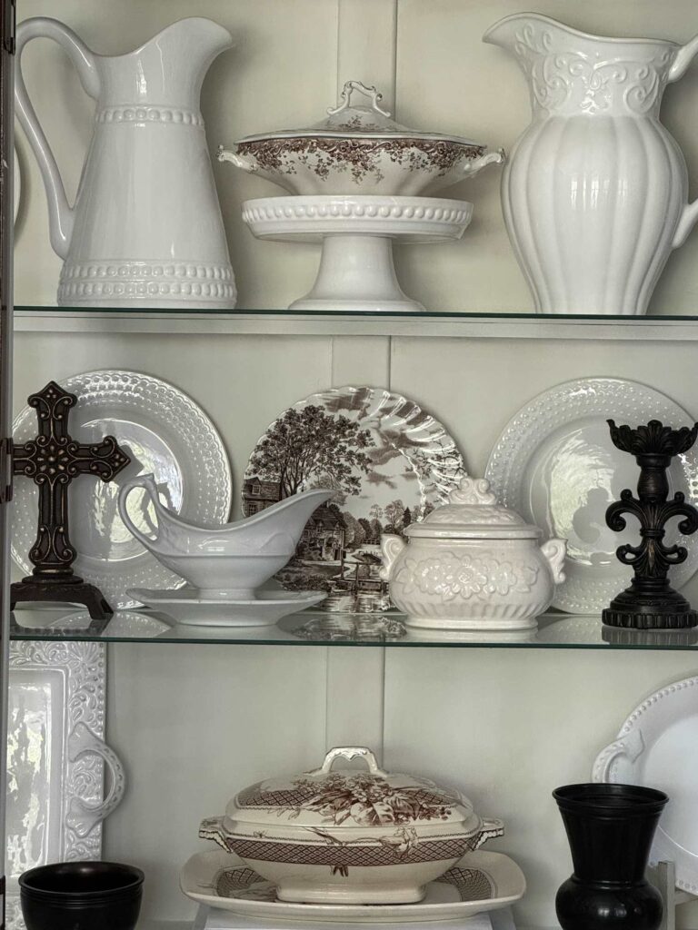 White and brown dishes organized in a china cabinet. 