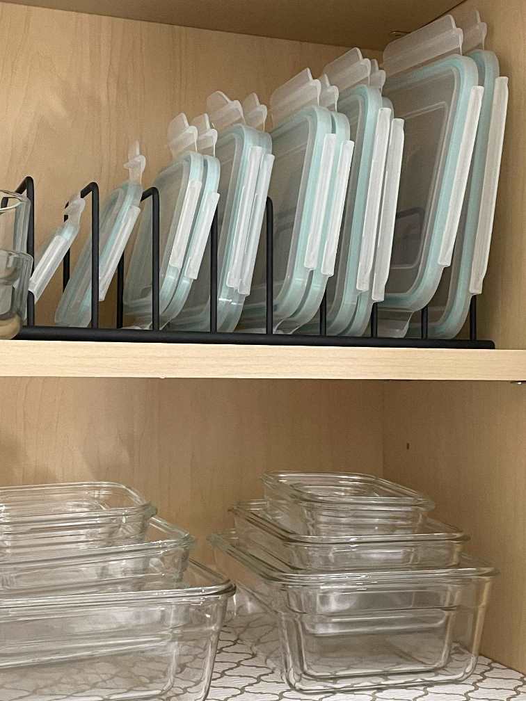 Glass bowls and plastic lids organized in a cabinet during the Winter Home Organization Challenge. 