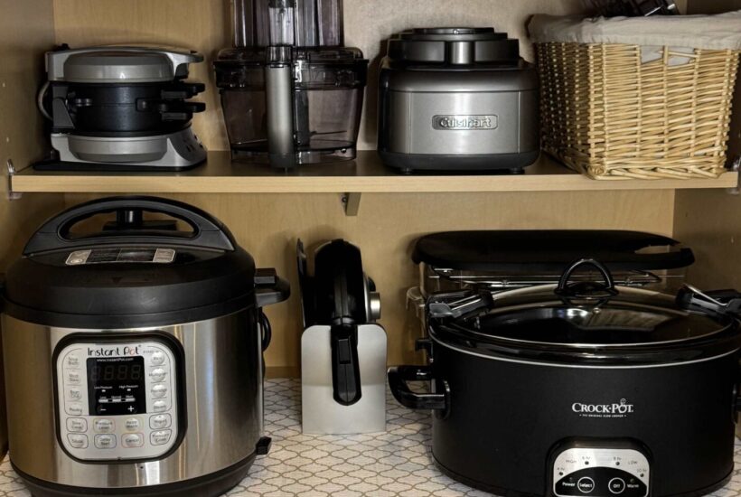Kitchen appliances organized in a cabinet.