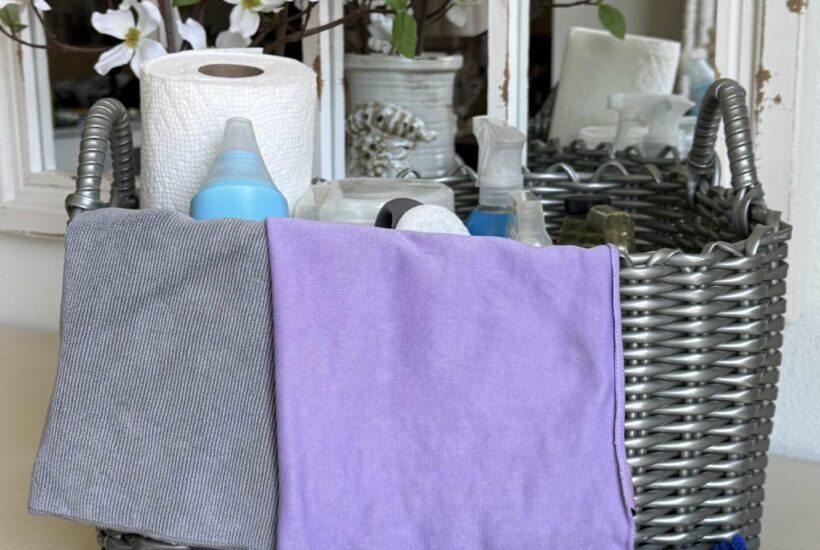 Gray basket holding cleaning products with duster in front.