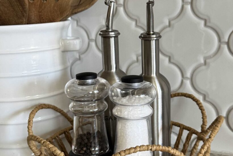 Salt, pepper, oil, and vinegar organized in a basket.