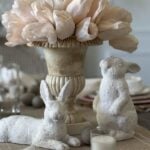 Urn filled with tulips and two white bunnies.