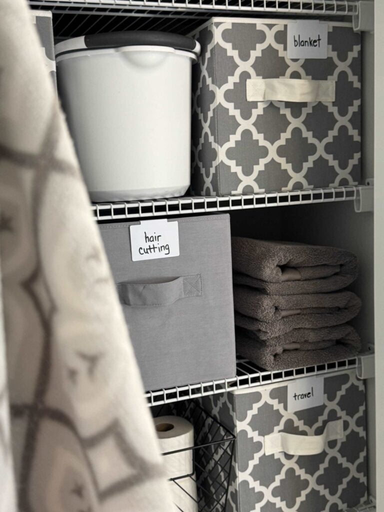 A gray and white organized bathroom closet.