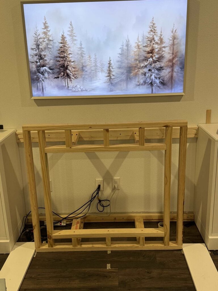 Picture of fireplace insert framing being test fitted between cabinets