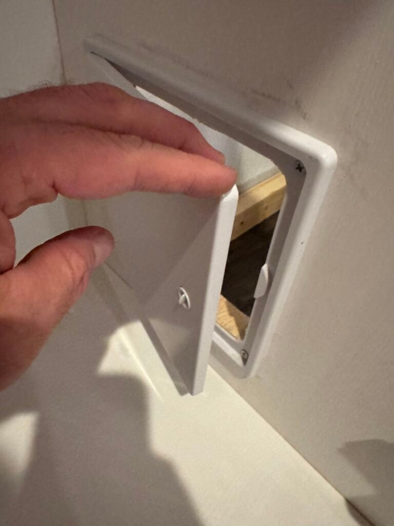 Hand opening access panel door inside cabinet