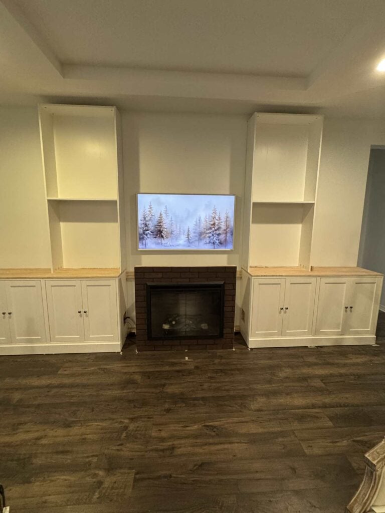 Four white base cabinets and two bookshelves are part of an IKEA cabinet hack. 