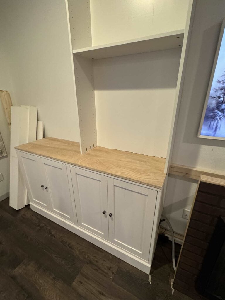 Two white cabinets with oak countertop attached to top and book cases sitting on top of cabinet