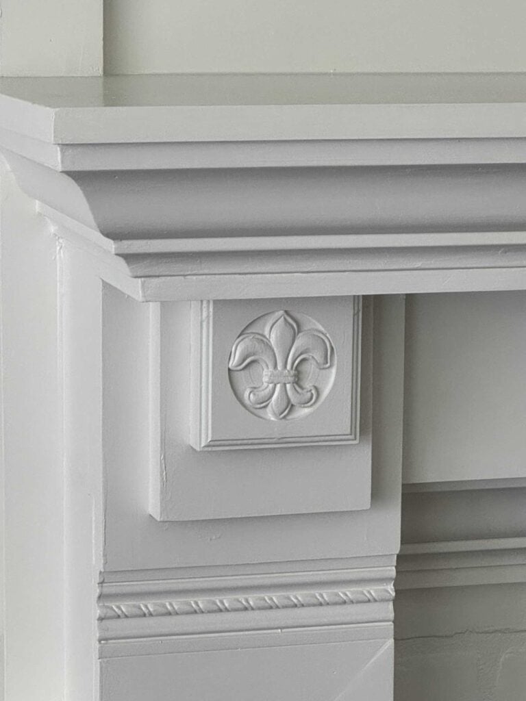 Woodwork on a white mantel. 