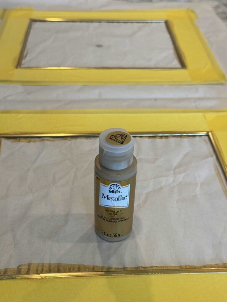 Mats covered with painter's tape while the edge is being painted with gold metallic paint. 