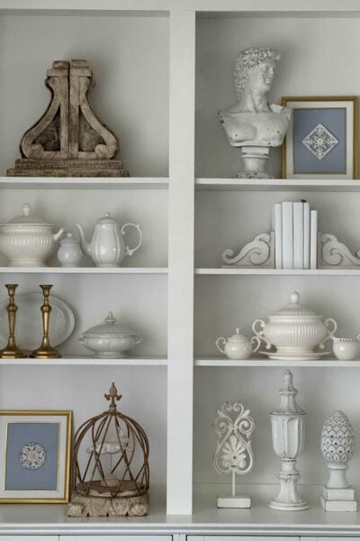 Living room book shelves decorated with blue and white thrifted items.