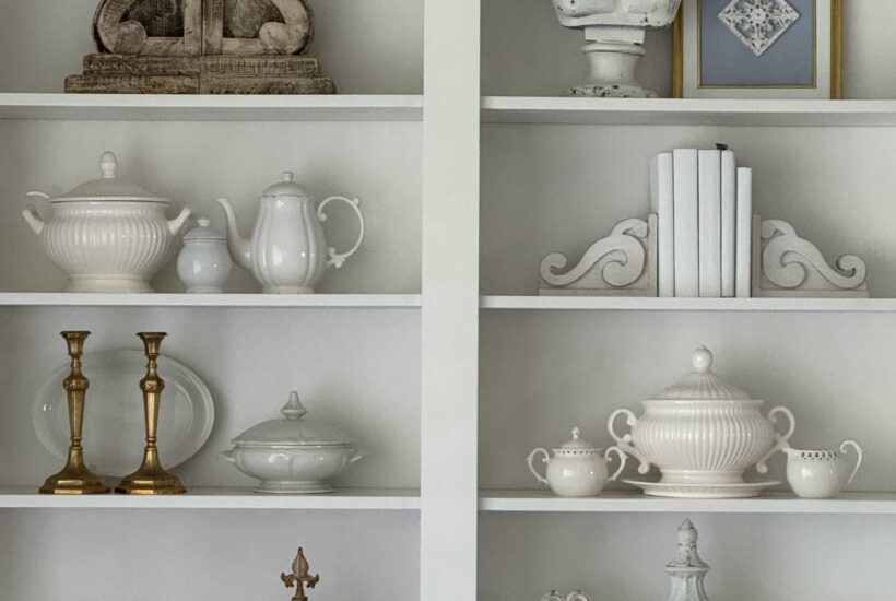 Living room book shelves decorated with blue and white thrifted items.
