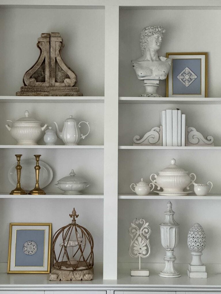 Shelves styled with blue and white items after an IKEA cabinet hack. 