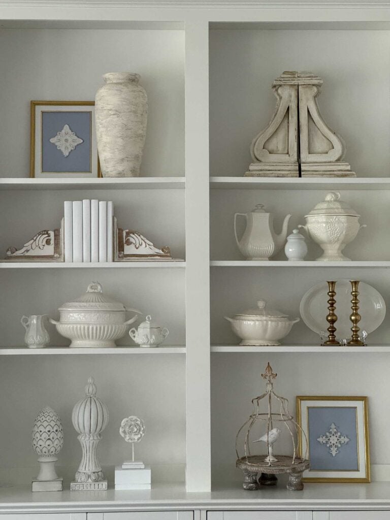 White bookshelves styled with blue and white items during an IKEA cabinet hack. 