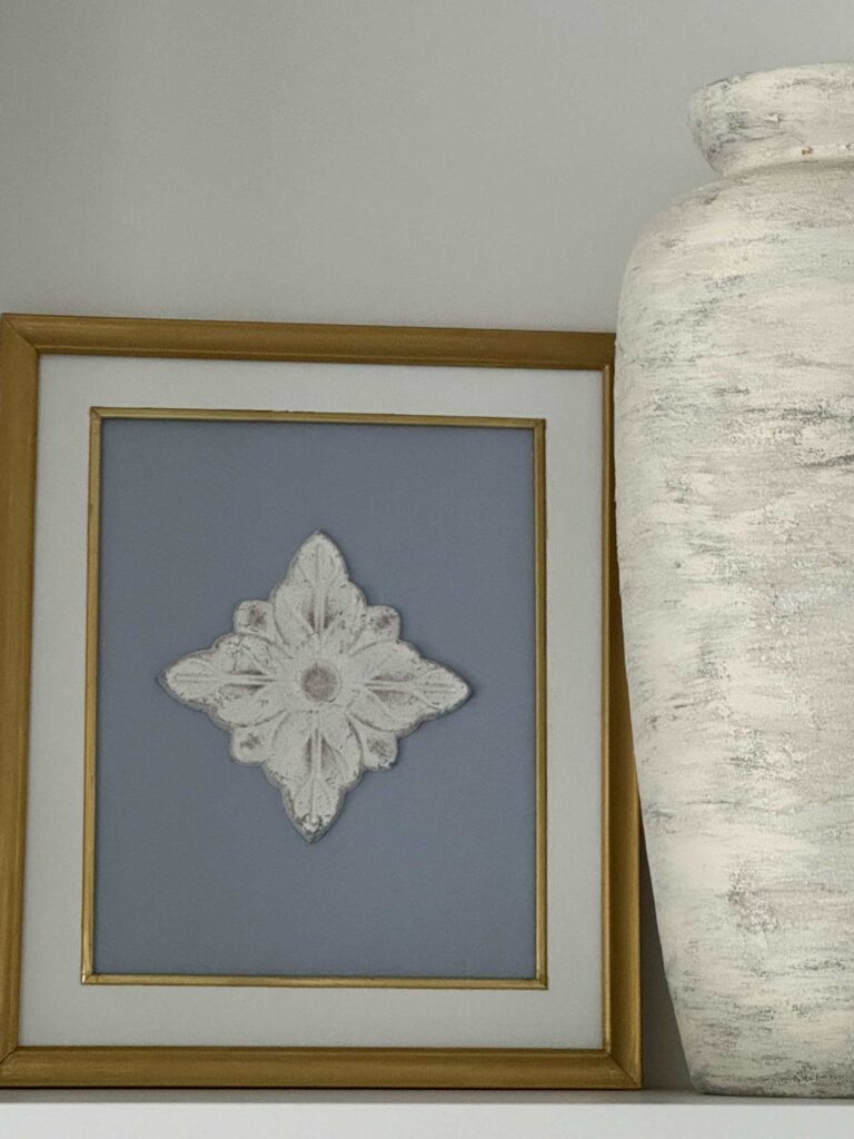 DIY framed art next to a large vase. 