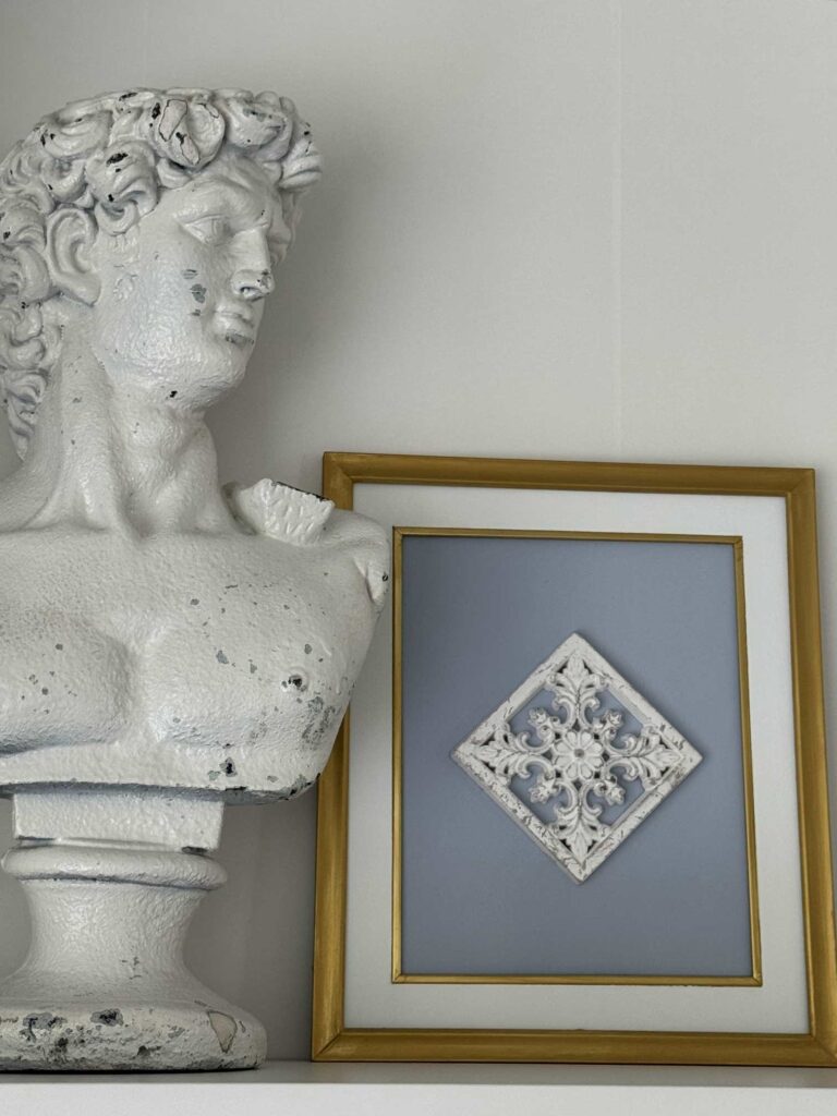 An antique bust next to DIY framed art. 
