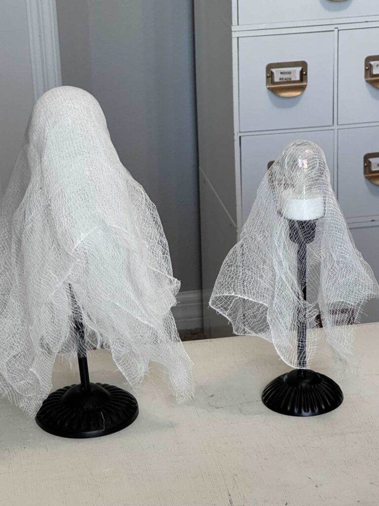 One candlestick covered with six layers of cheesecloth and another with one layer of cheesecloth. 