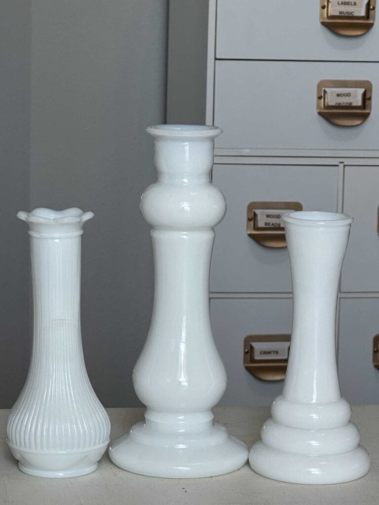 Three milk glass vases in varying heights. 